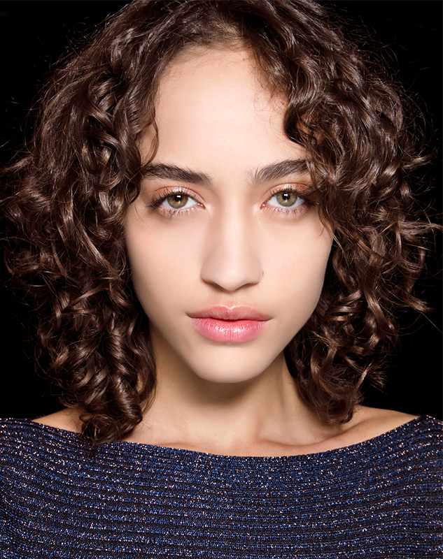 Best Anti-Aging Hair Products | woman with shiny curly hair