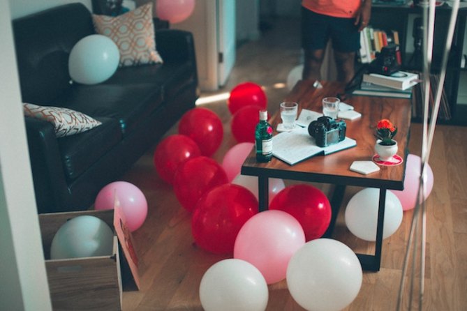 A living room filled with red and white balloons