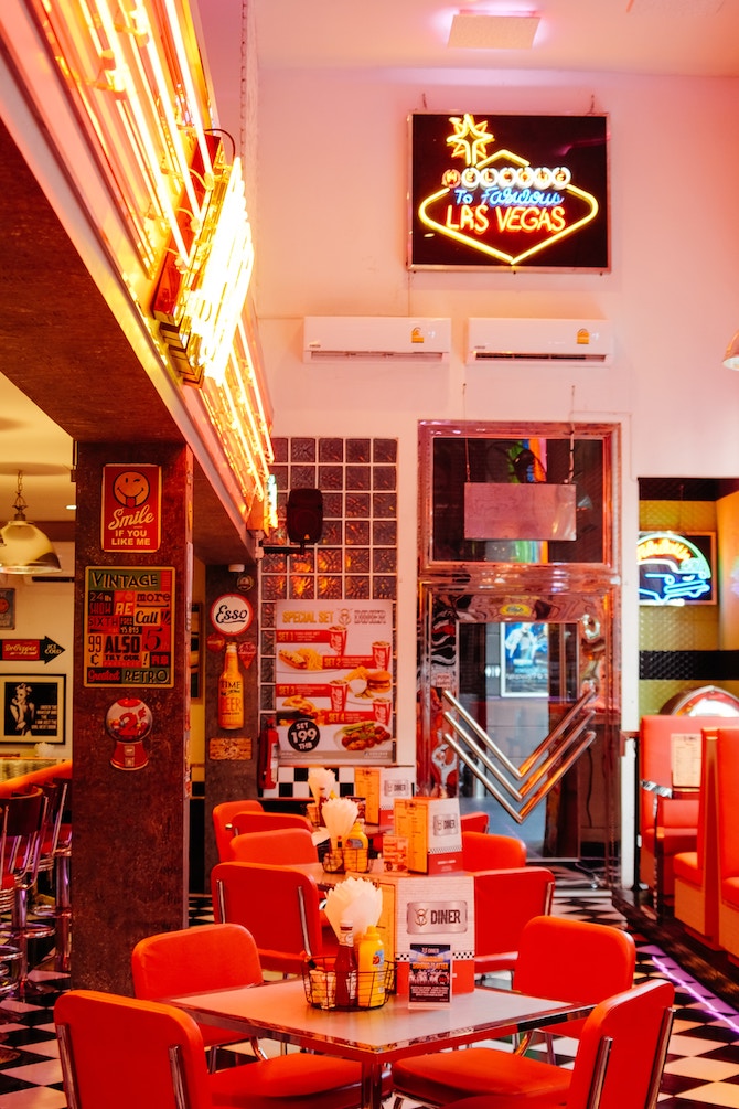 A diner with pink walls and red leather seats