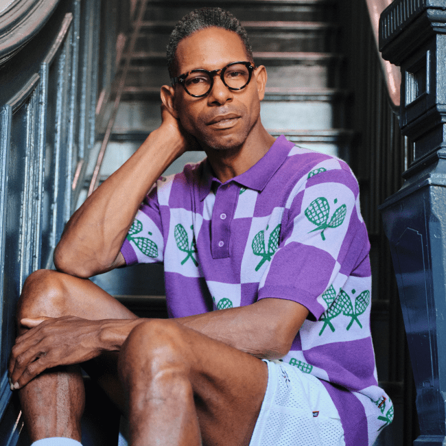 A model wearing a purple checked polo from Rowing Blazers