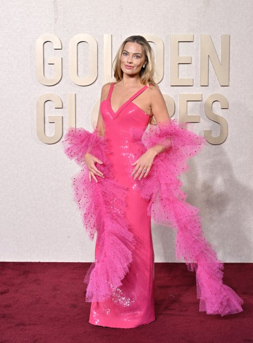 Margot Robbie wearing a hot pink floor length dress with a pink tulle boa.