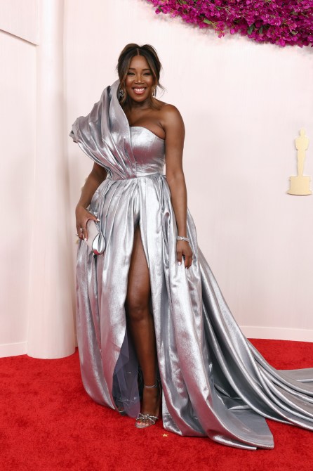 DJ Kiss at the 2024 Oscars red carpet wearing a one shoulder metallic silver gown