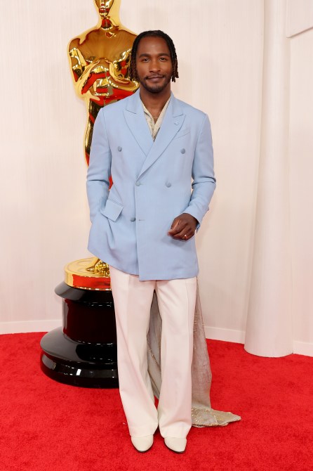 Scott Evans at the 2024 Oscars red carpet in a light blue double breasted jacket and white pants