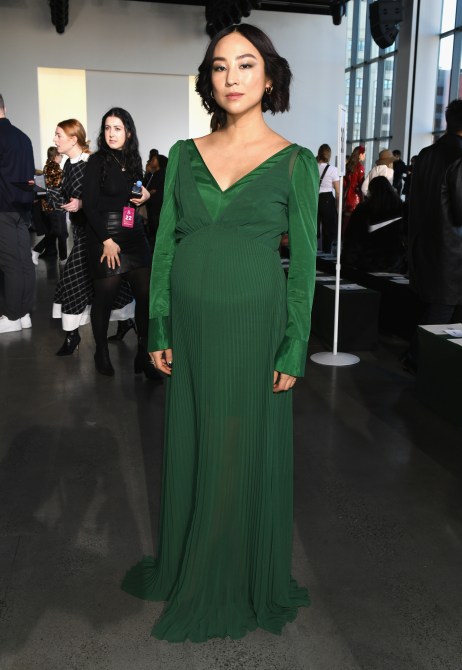 Greta Lee in an emerald green evening gown at a New York Fashion Week event