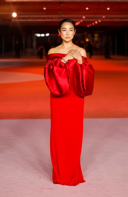 Greta Lee in an off-the-shoulder red evening gown with puff sleeves at the Academy Museum of Motion Pictures 3rd Annual Gala