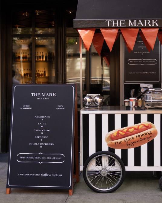 The outside of The Mark hotel, which features a striped hot dog stand and a large menu