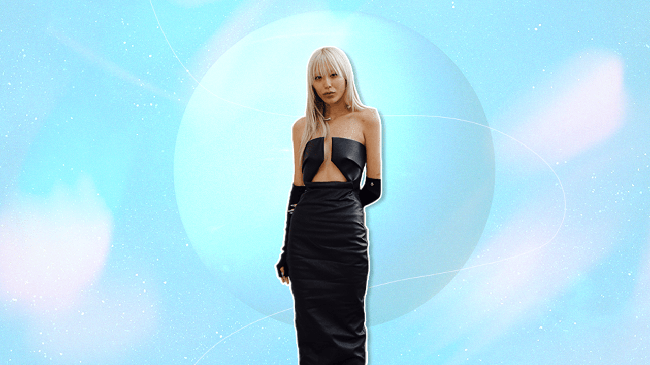 A woman in a black cocktail dress standing in front of a light blue planet Neptune with a light blue background