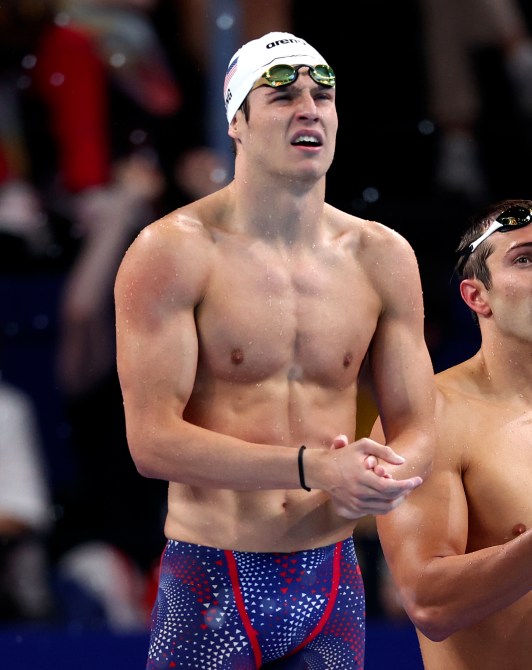 Matt King and Ryan Held of Team United States react during the Men's 4x100m Freestyle Relay Heats on day one of the Olympic Games Paris 2024 at Paris La Defense Arena on July 27, 2024 in Nanterre, France
