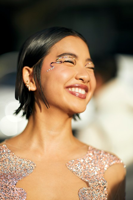 A fashion week guest wearing huggie earrings.