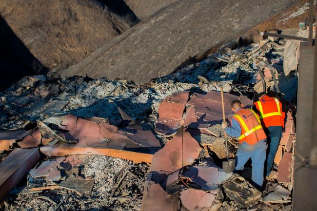 Gas company workers look for a gas line in the ruins of house that was destroyed in the Woolsey Fire in Malibu, California on November 14, 2018. - Firefighters backed by air tankers and helicopters battled California's raging wildfires for a seventh day on Wednesday as the authorities in the worst-hit county released a list of over 100 missing people. Cal Fire said more than 3,500 fire personnel were battling the "Woolsey Fire," which has destroyed the Malibu homes of several celebrities including Miley Cyrus, Neil Young, Robin Thicke, Shannen Doherty and Gerard Butler. At least 51 deaths have been reported so far from the deadliest wildfires in California's recent history and body recovery teams were going house-to-house with cadaver dogs in Paradise.