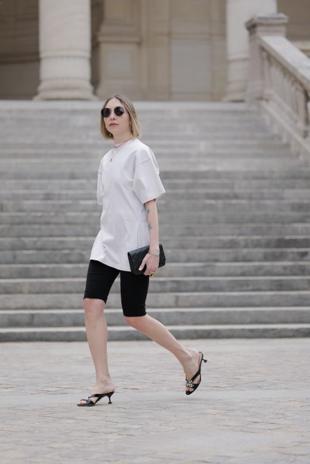 Emy Venturini wears sunglasses from Balenciaga, a necklace , a white oversize t-shirt from Balenciaga, shorts / leggings from The Frankie Shop, a Chanel bag, a Cartier watch, bejeweled shoes from Miu Miu, a Prada bracelet, during a street style fashion photo session, on June 10, 2024 in Paris, France.