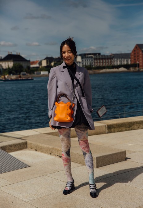 A fashion week guest wearing printed tights.
