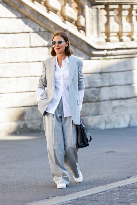 Fashion Designer Eva Lutz, wearing a white blouse by Dries van Noten, a light grey checked suit by Dries van Noten, white sneakers by Axel Arigato, a black bag by Hogan and sunglasses by Marc o Polo, during a streetstyle shooting on September 11, 2024 in Wuerzburg, Germany.