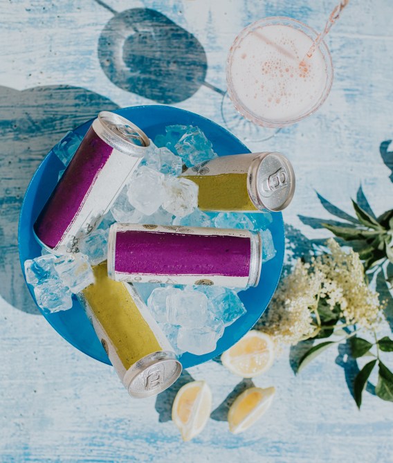Cans of drink sit in a bowl full of ice.