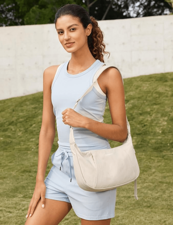 A model carrying the G4Free Crossbody Bag in beige