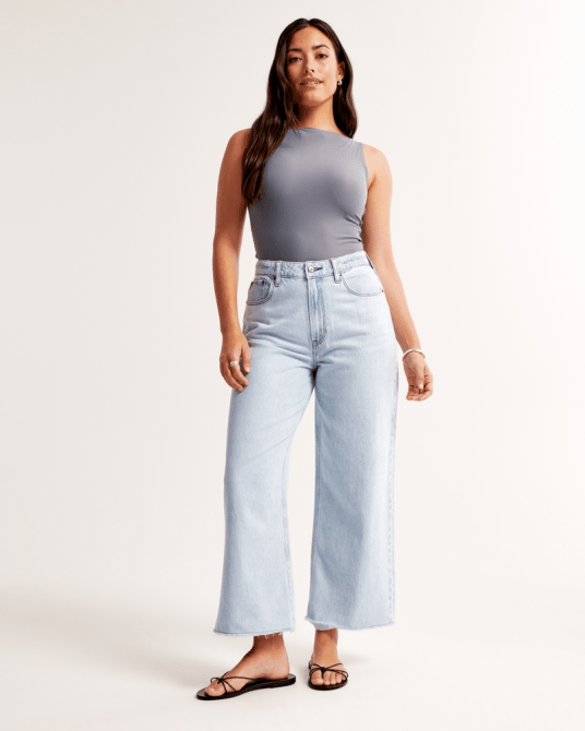 A model wearing Abercrombie & Fitch's Curve Love High Rise Cropped Wide Leg Jean in a light wash
