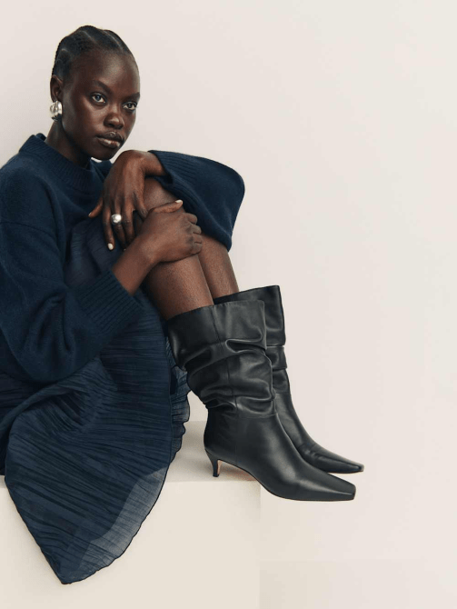 A model wearing Reformation's Rosie Mid Shaft Boot
